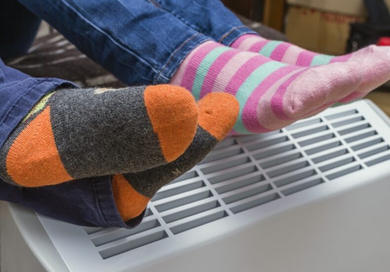 Homeowners warming their feet after following the furnace maintenance tips